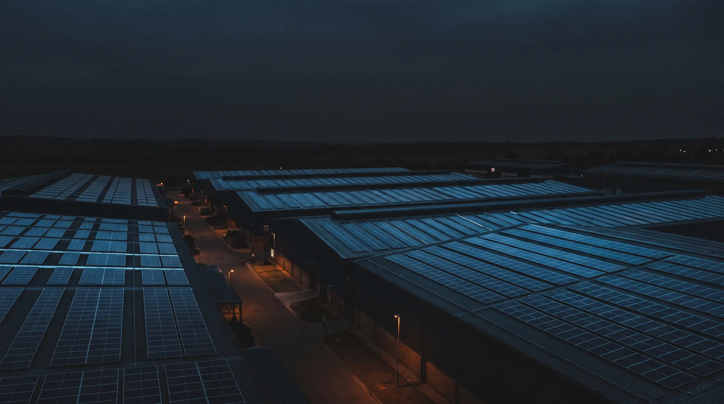 Rooftop solar arrays across a commercial park at dusk